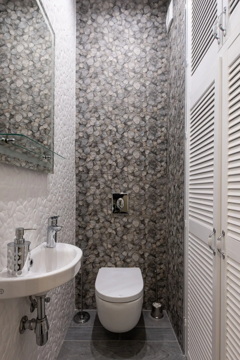 Pequeño cuarto de baño con lavabo, dosificador de jabón e inodoro